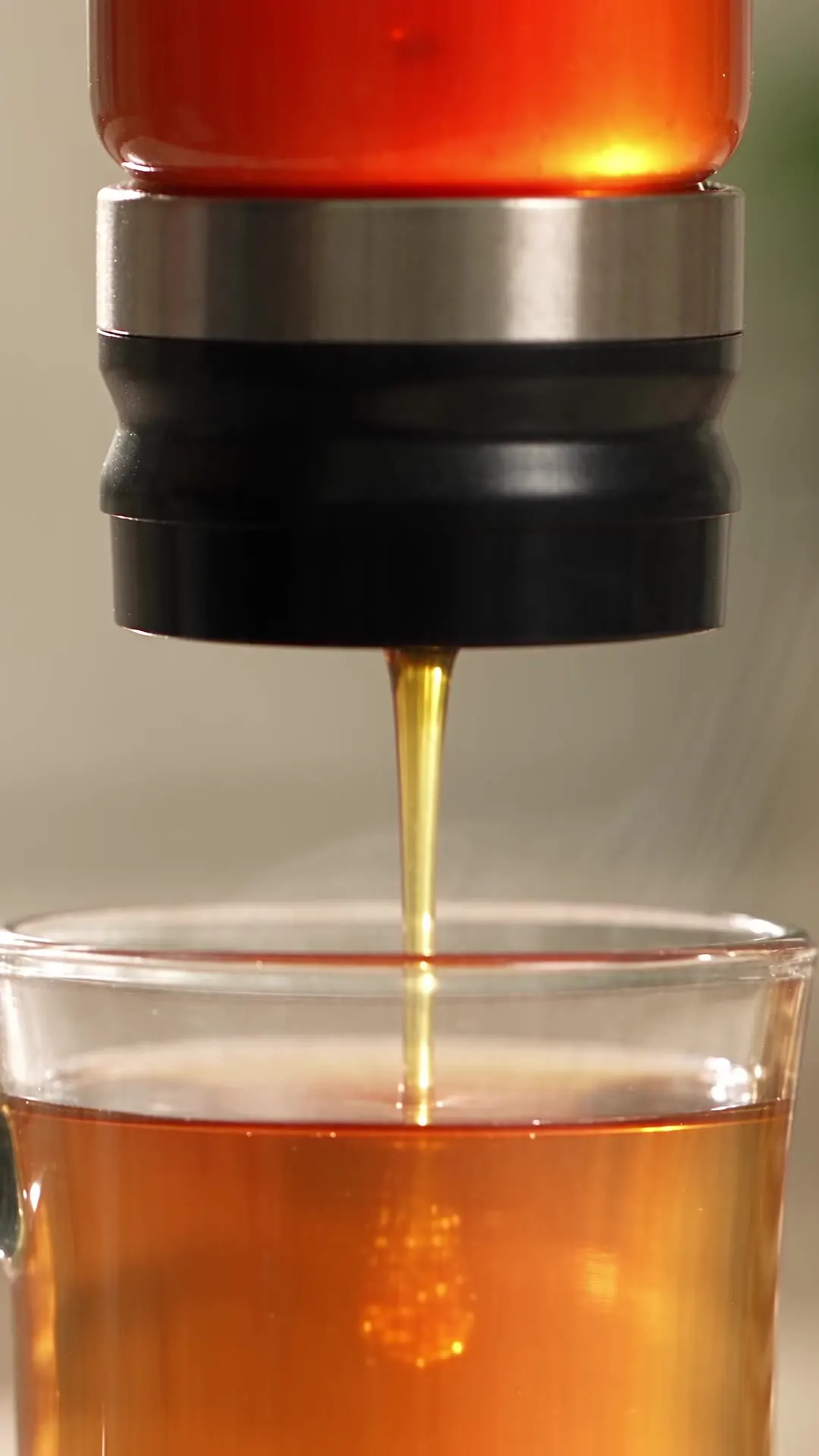 Honey pouring into a glass of tea