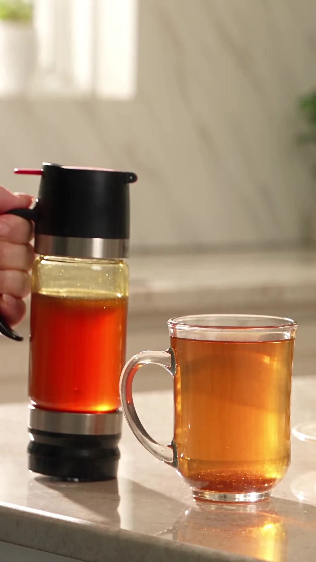 HoneyJar next to a glass mug of tea on a marble counter